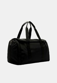 Borsa a sacca nera realizzata in nylon, con doppie maniglie e chiusura a zip. Le cinghie testurizzate con dettagli del logo offrono una presa aggiuntiva.