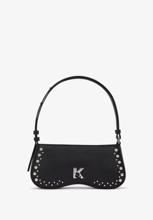 Czarna skórzana torebka z zaokrąglonymi krawędziami, srebrnym logo i dekoracyjnymi ćwiekami po jednej stronie. Posiada cienki, regulowany pasek na ramię.