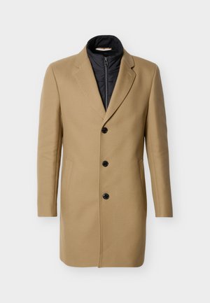 Manteau trois boutons couleur chameau avec doublure intérieure zippée noire, col et poches latérales, présenté sur fond blanc.