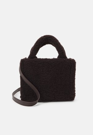 Brown, textured handbag made of soft fleece material with a rectangular shape, dual top handles, and a detachable brown strap.
