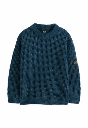 Maglione lavorato a maglia di colore blu scuro con scollatura rotonda, motivo testurizzato, polsini e orlo a coste, e un piccolo etichetta nera sulla manica.