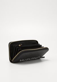Black leather wallet featuring a gold zipper, multiple compartments, and embossed logo detail. The interior includes organized slots.