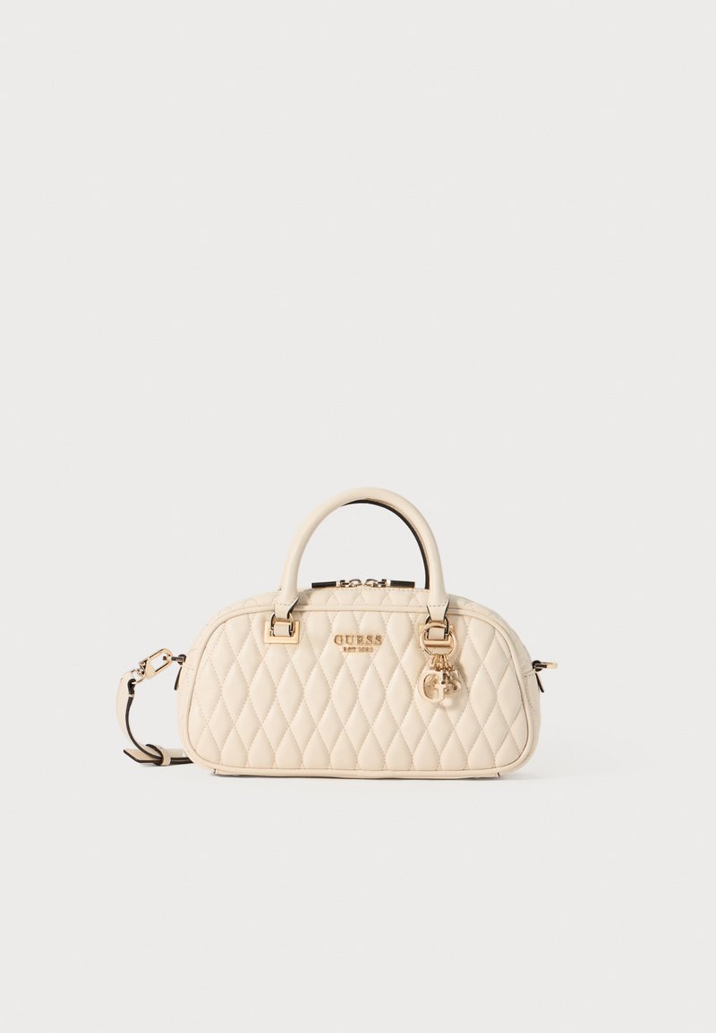 Quilted cream handbag with gold hardware, dual top handles, and an adjustable shoulder strap. Features a key charm and logo detail.