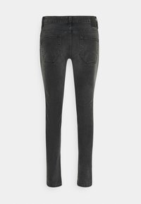 Schwarze Skinny-Jeans aus Denim mit ausgewaschenem Finish, ausgestattet mit Gesäßtaschen und einem normalen Bund. Keine sichtbaren Verzierungen oder Muster.