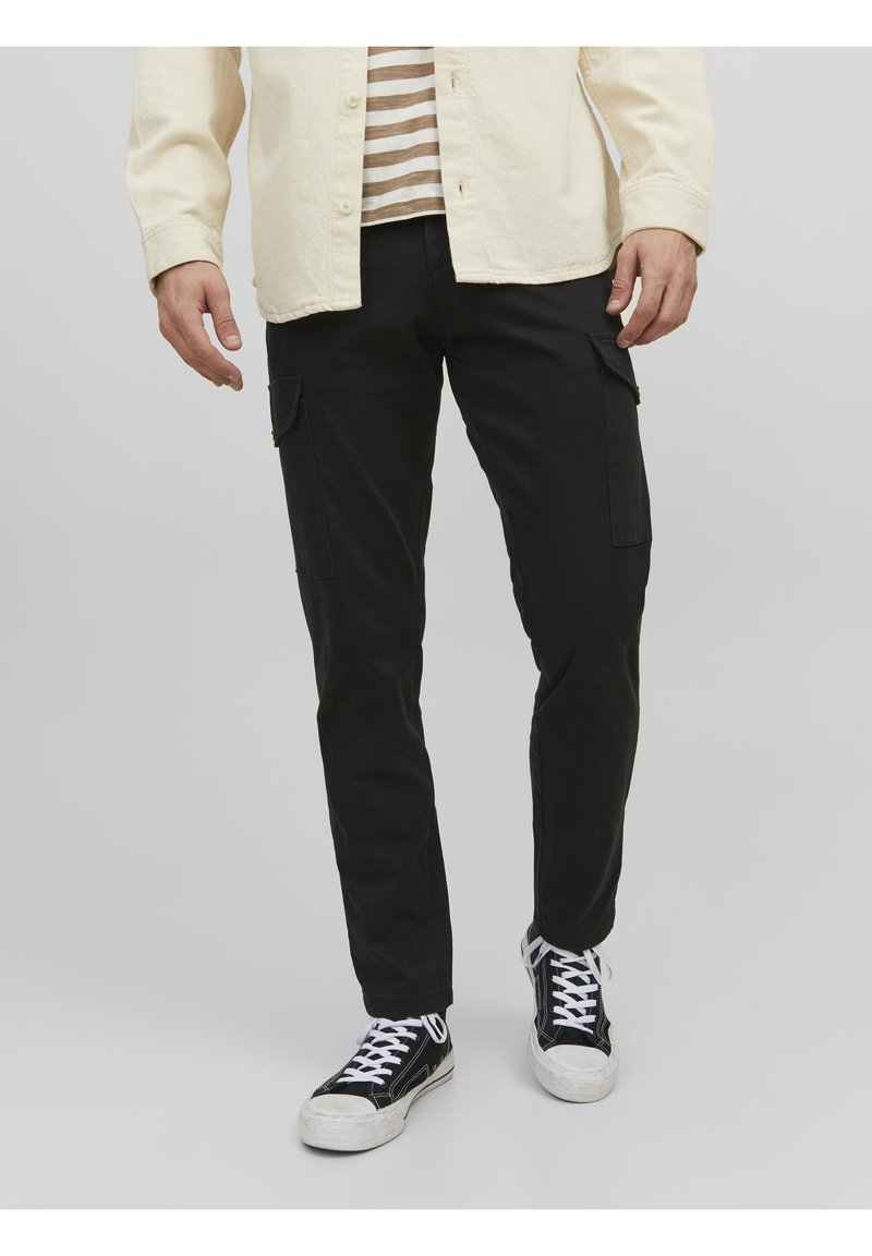 Svarta cargobyxor med två sidofickor, slim fit-design och en mjuk textur. Matchas med svarta sneakers och en randig skjorta.