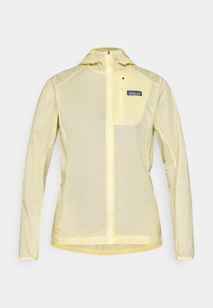 Lett gul regnjakke med glidelås foran, justerbar hette og en brystlomme med logo. Laget av et pustende materiale.