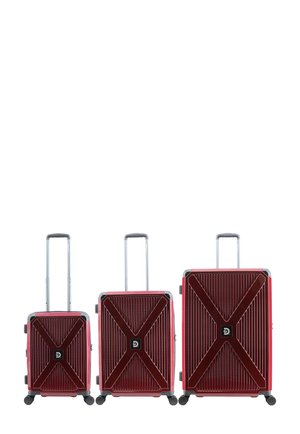 Three red hard-shell suitcases of small, medium, and large sizes with extended telescopic handles and four black wheels each.