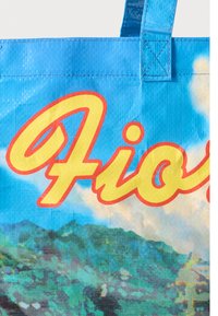 Modrá taška z odolného materiálu, se svěžím potiskem s nápisem "Fiore" v žluté barvě a texturovaným designem připomínajícím krajinu.