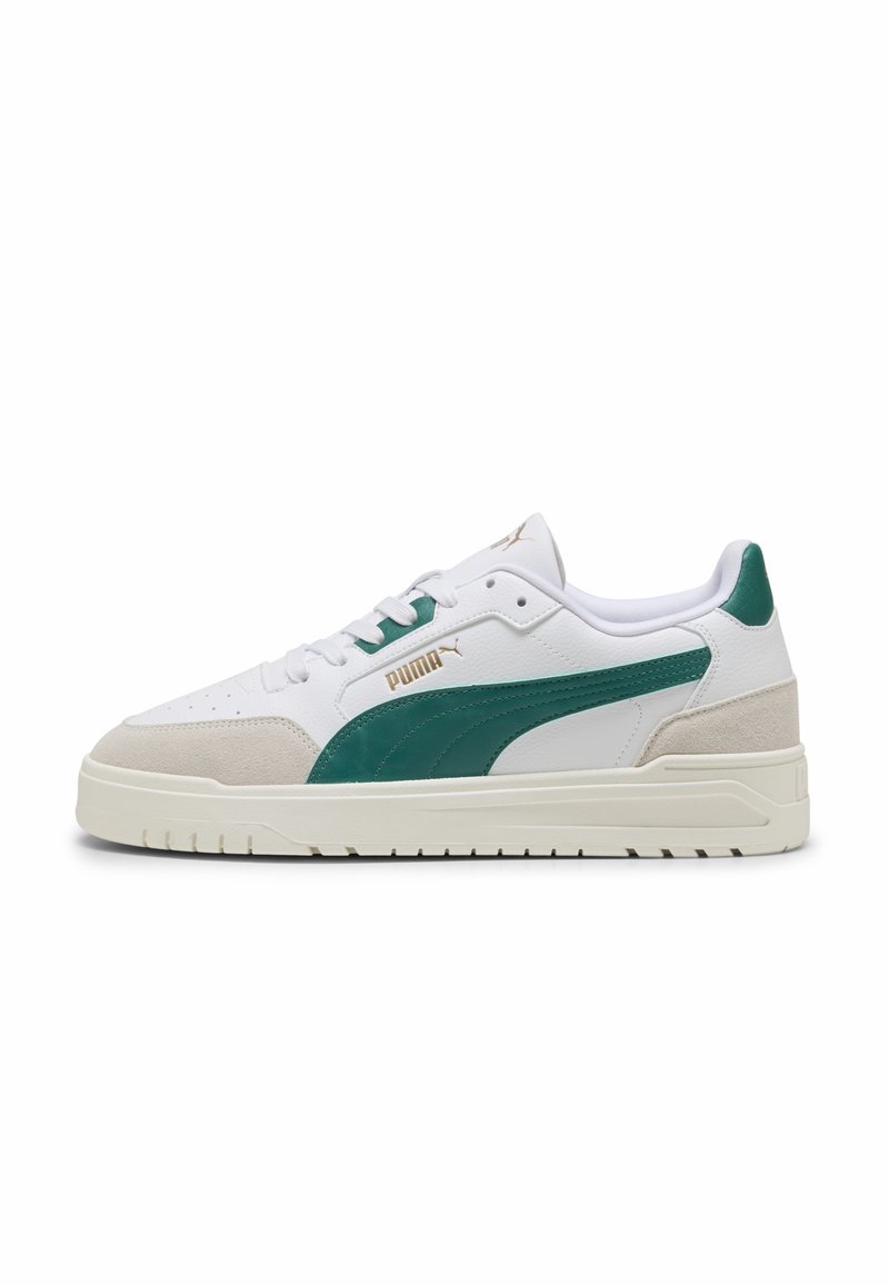 Hvide sneakers med grønne accenter, med en tekstureret læder- og ruskindsdesign, rund tå, flad sål og guld branding på siden.