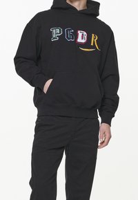Sort hættetrøje lavet af bomuldsblanding med en kængurulomme, ribstrikkede manchetter og broderede, flerfarvede bogstaver "PGDR" på forsiden.