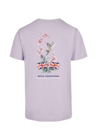Lilac cotton t-shirt featuring floral and hummingbird graphics, Union Jack accents, and the text "Royal Expeditions" in navy.