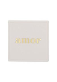 Biały prostokątny obiekt z wyrazem "amor" wytłoczonym złotem na środku jego powierzchni.