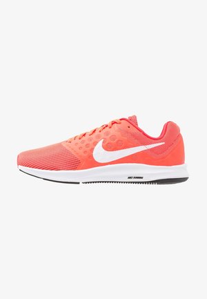 Chaussure de course Nike couleur corail rose avec logo swoosh blanc, tige en mesh texturé et semelle blanche avec accents de bande de roulement noirs.