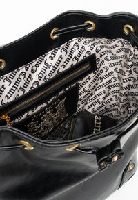 Sac seau en cuir noir avec des œillets en métal doré et un intérieur doublé avec un texte répété. Comprend une poche zippée et des accents décoratifs.