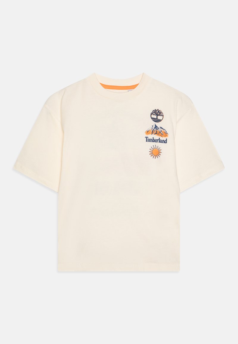 Cream short-sleeve t-shirt featuring patterned embroidered logos: a tree, mountains with “Timberland,” and a sun. Crew neck. Soft cotton material.