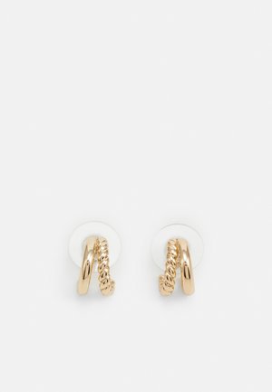 Gold-tone double hoop earrings with one smooth and one twisted textured hoop on clear plastic backings on white background.