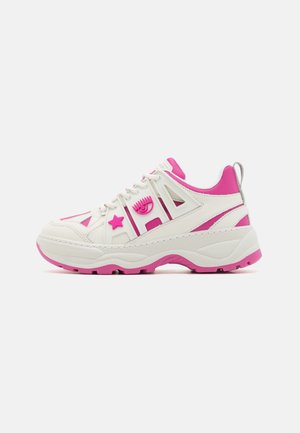 Sneaker bianco con dettagli rosa, caratterizzato da una suola spessa, chiusura con lacci, grafica a stella e occhio, e pannelli laterali con ritaglio.