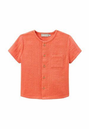 Chemise corail à manches courtes avec un col rond, cinq boutons en bois sur le devant et une petite poche poitrine. Tissu texturé.