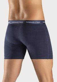 Námornícke boxerky vyrobené z mäkkého materiálu, s priliehavým strihom a širokým pásom so logom "Copenhagen Studios" v bielej farbe.