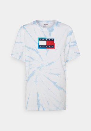 Bílá tričko s modrým tie-dye vzorem, s obdélníkovým logem s nápisem "TOMMY JEANS" v černém písmu na barevném pozadí.