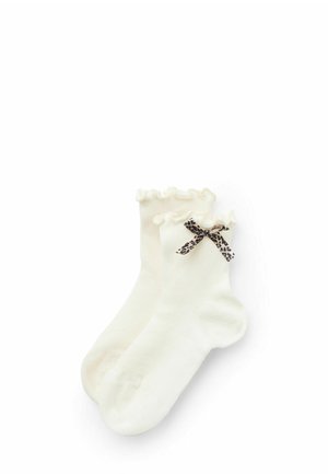 Stickade crémefärgade strumpor med en volang överst och ett svart och beige leopardmönstrat band som accent. Mjukt material och ankel-längd.