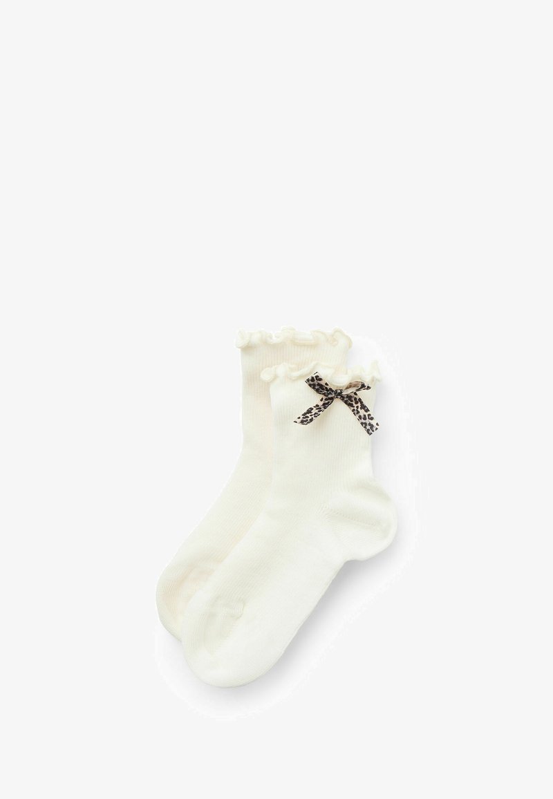 Gestrickte cremefarbene Socken mit einer Rüsche am oberen Rand und einem schwarzen und beige Leopardenmuster-Ripsband als Akzent. Weicher Stoff und Knöchellänge.