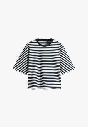 Csíkos, rövidujjú póló fehér és sötétkék színben. Kerek nyakkivágása van és laza fazonú, vízszintes csíkokkal. Pamutból készült.