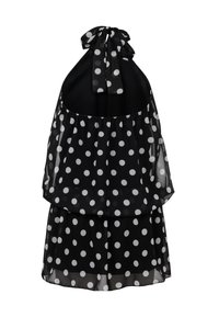 Robe dos nu noire à pois blancs, tissu transparent superposé et fermeture par nœud papillon au cou.