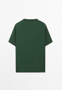 T-shirt uni vert foncé à manches courtes et col rond, vu de dos sur un fond blanc uni.
