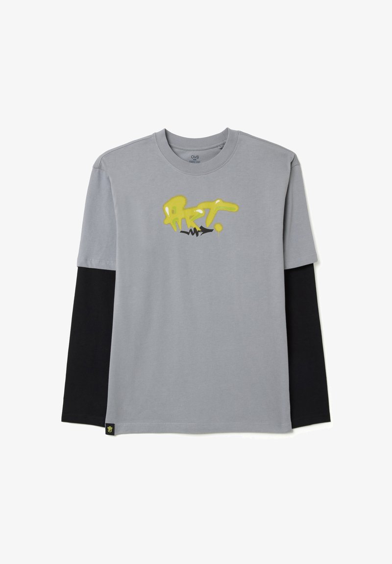 Grijze lange mouwen shirt met een zwarte ondermouw, voorzien van een geel en zwart graffiti-achtige "kunst" ontwerp op de voorkant. Zacht katoen.