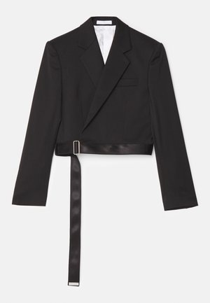 Melnā īsā žakete ar elegantu dizainu, divrindu priekšpusi, asas atlokiem un siksnu ar satīna pieskārienu, kas ir piesprādzēta ar metāla sprādzi.