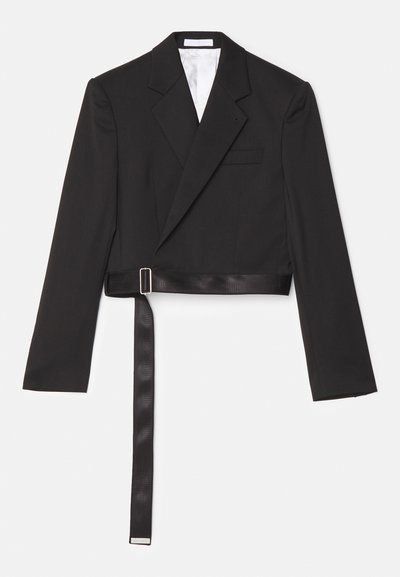 Mustal lühike bleiser, millel on sujuv disain, topelt eest kinnituv, teravad kraed ja satiinist tunne, vöö, mis on kinnitatud metallist pandlaga.