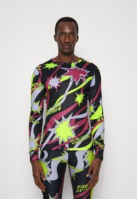 Schwarzes sportliches Langarmshirt mit lebhaften, mehrfarbigen Sternenmustern in Grün, Pink und Grau. Enganliegendes Design aus dehnbarem Material.