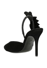 Scarpa nera in suede con tacco alto, punta chiusa, cinturino alla caviglia con dettaglio a catena e un accentuato volant sul retro. Taglia 37.
