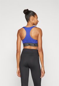 Puma KEEPS BRA - Sport-BH mit mittlerer Stützkraft - lapis lazuli