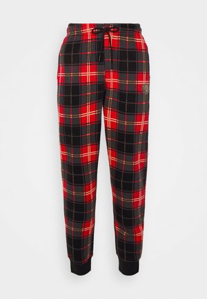 Pantaloni della tuta a quadri rossi e neri con vita regolabile tramite coulisse, polsini a coste e un piccolo logo sulla coscia destra. Realizzati in morbido tessuto.