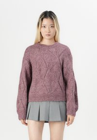 Pleteni pulover s dijamantnim uzorcima u mauve boji, s rebrastim manžetama i donjim rubom, s opuštenim krojem. Uparen sivi suknja s plisama.