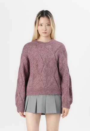 Strikket genser i mauve med diamantmønster, ribbede mansjetter og nederkant, med en avslappet passform. Kombinert med et grått plissert skjørt.