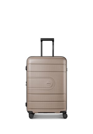 Valigia rigida beige con scanalature orizzontali, quattro ruote nere girevoli e manico estensibile nero.