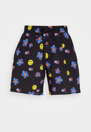Pantaloni corti neri con un motivo colorato di fiori, faccine sorridenti e bandiere. Realizzati in tessuto leggero con vita elastica e cordoncino.