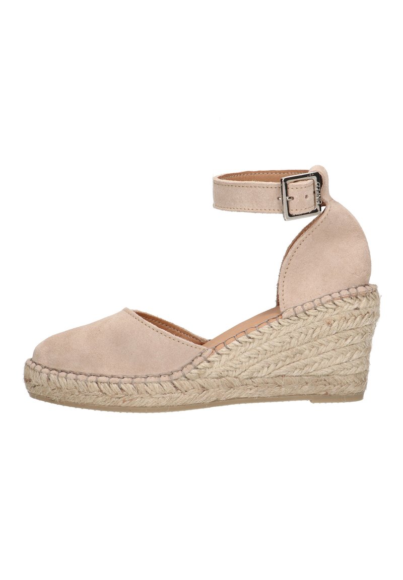 Beige suede espadrille wedge with an ankle strap, featuring a braided jute heel and a rounded toe. Smooth texture with minimal stitching.