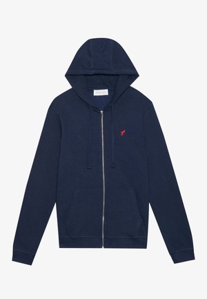 Navy zip-up hoodie made of soft fabric, featuring a front pocket, drawstring hood, and embroidered red bird logo on the chest.