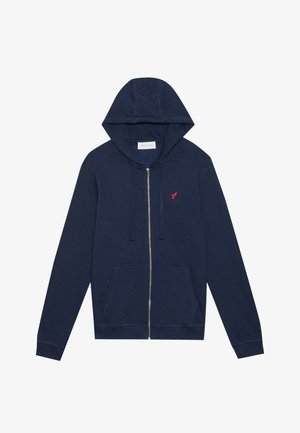 Navy zip-up hoodie made of soft fabric, featuring a front pocket, drawstring hood, and embroidered red bird logo on the chest.