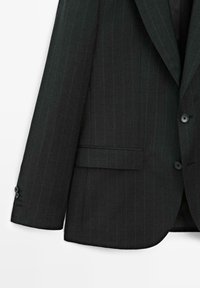 Schwarzes Blazer mit Streifenmuster und strukturiertem Design, zwei vorderen Knöpfen und einer einzelnen Brusttasche, gefertigt aus einem strukturierten Stoff.