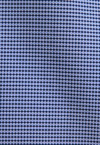 Tissu bleu et blanc à petits carreaux avec des plis subtils créant des ombres douces et une texture.