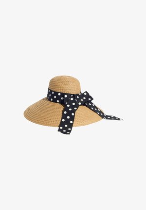 Széles karimájú szőtt szalmakalap, fekete-fehér pöttyös szalaggal, amely masnira van kötve a kalap tetején.