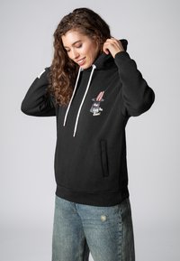 Zwarte hoodie van zachte stof met een trekkoord, met een konijnenontwerp met roze oren en de tekst "Geniet van de Show!" op de voorkant.