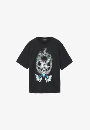 Zwart T-shirt met korte mouwen met een afbeelding van een brandende schedel omringd door groene bladeren en twee witte handen eronder met blauwe vlammen.