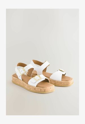 Hvide sandaler med to brede stropper og spænde. Korksål med lys brun polstring. Flad design, velegnet til afslappet brug.