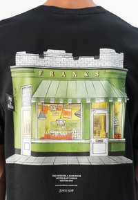 Franks Pie & Mash boltja kívülről, zöld homlokzattal, árnyékolóval, vitrinnel, ajtóval és alatta a kapcsolattartási adatokkal.